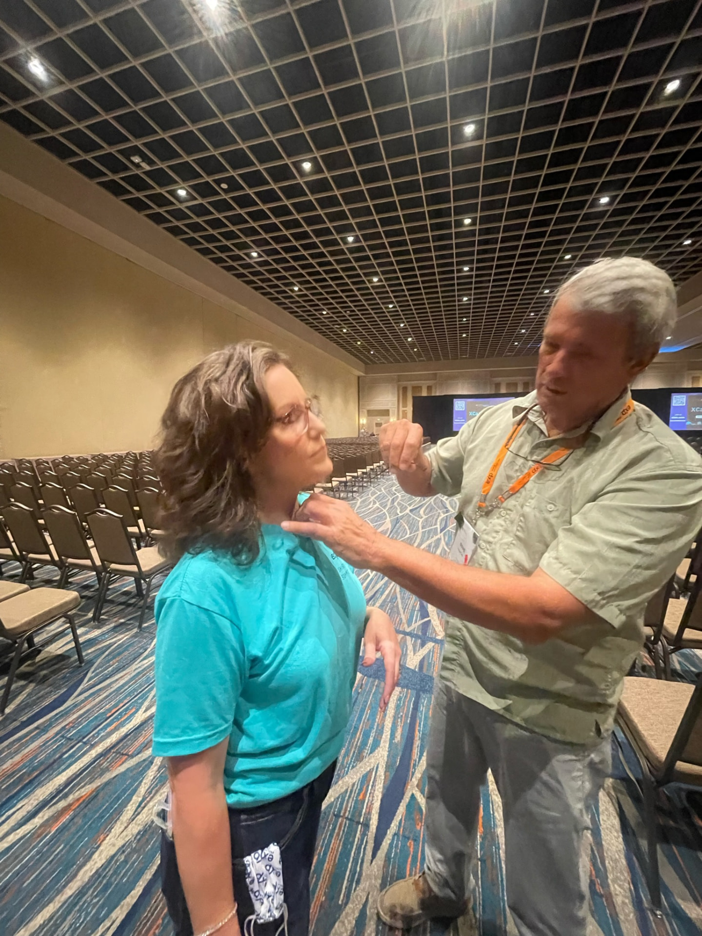 An AV crew member mic's Renee Funk up before the XCAMP session begins