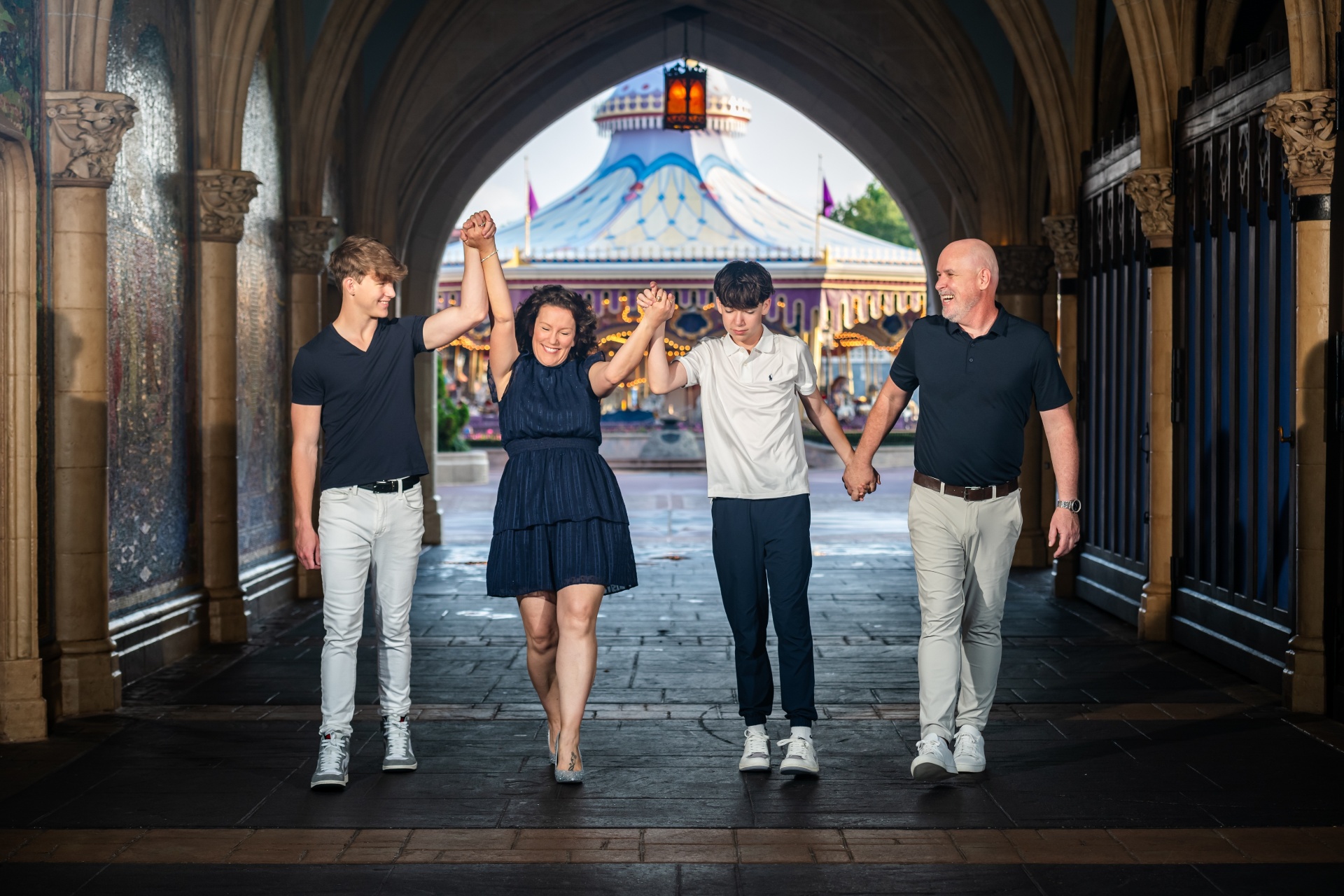 The Funk family walking hand-in-hand through a castle archway at Magic Kingdom before the park opened